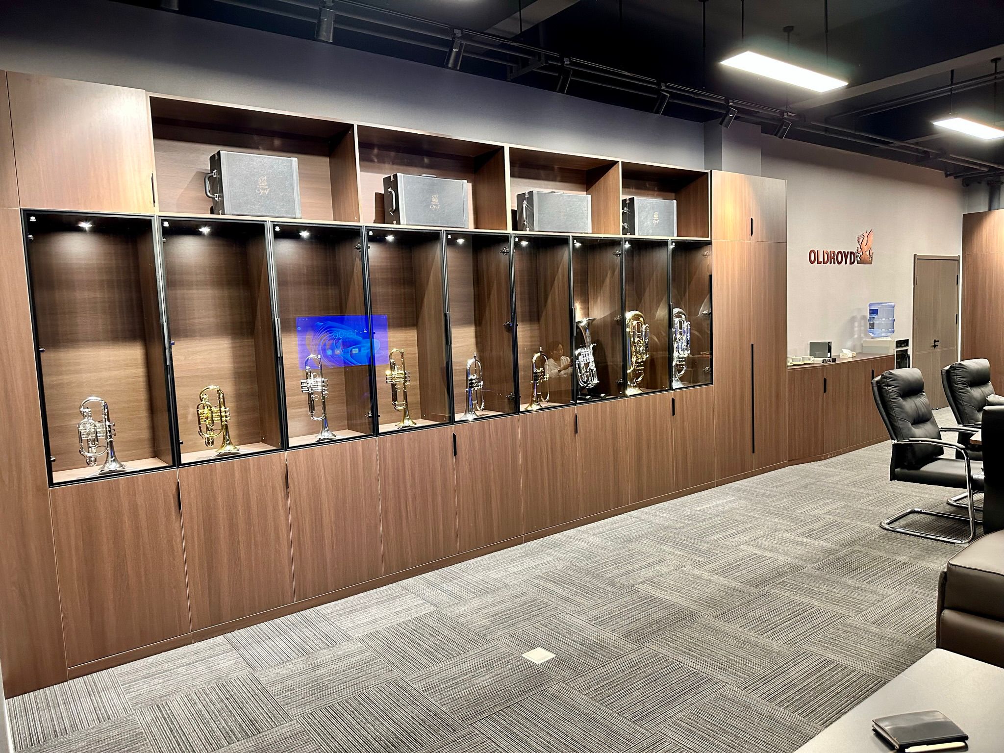 The Oldroyd showroom, with brass instruments displayed in illuminated glass cabinets